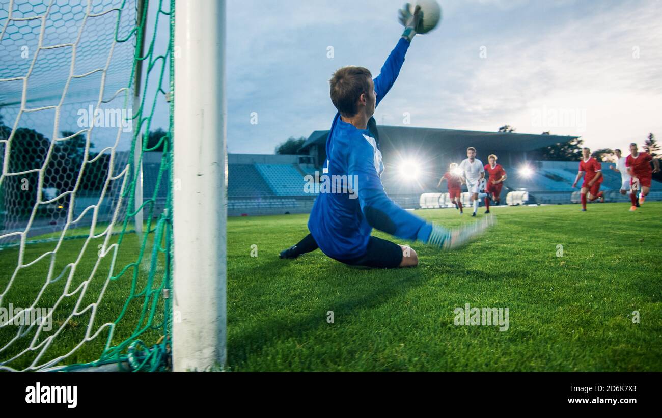 Auf Stadion Angreifer Kicks the Ball und Tore, Fußball Torwart versucht, Tore springt und fangen den Ball zu verteidigen. Stockfoto
