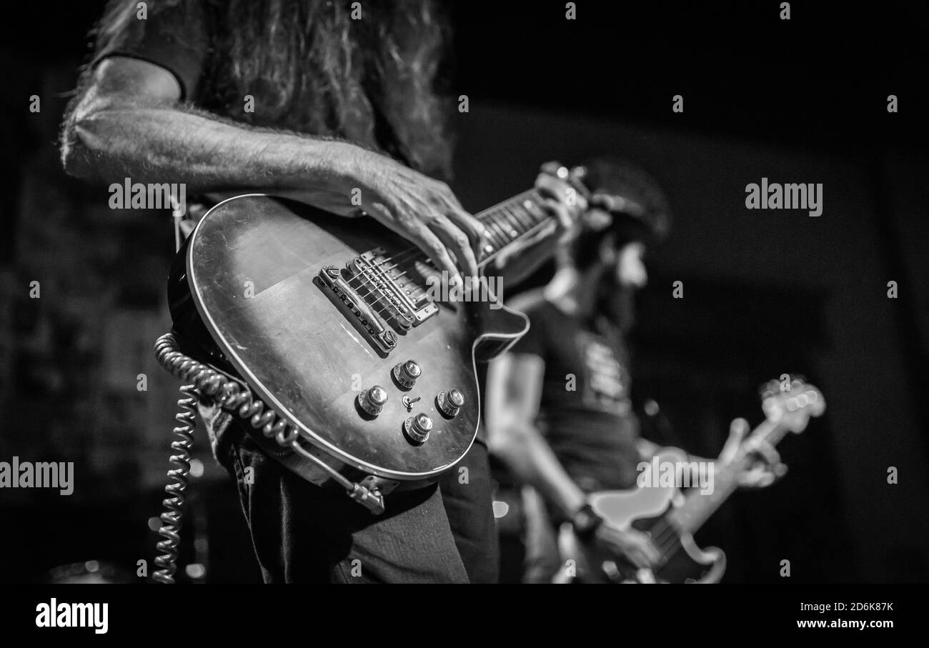 Schwarz-Weiß-Aufnahme einer Rockband, die live auftrat Auf der Bühne Stockfoto