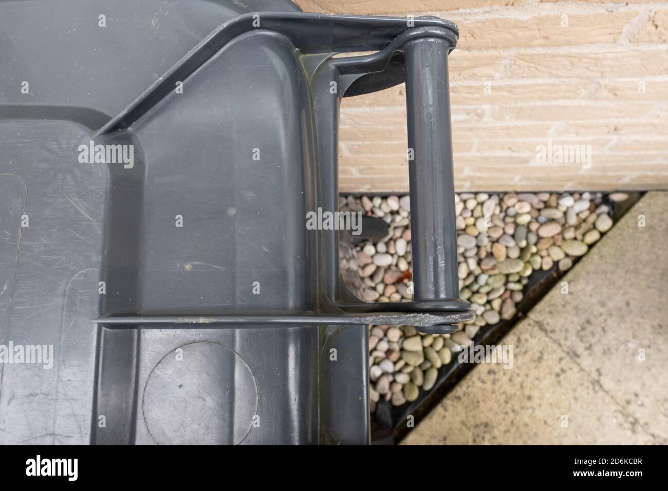 Abstrakte Ansicht eines typischen Haushaltsmüll Mülltonne außerhalb einer Küchenwand auf einem privaten Grundstück gesehen. Stockfoto