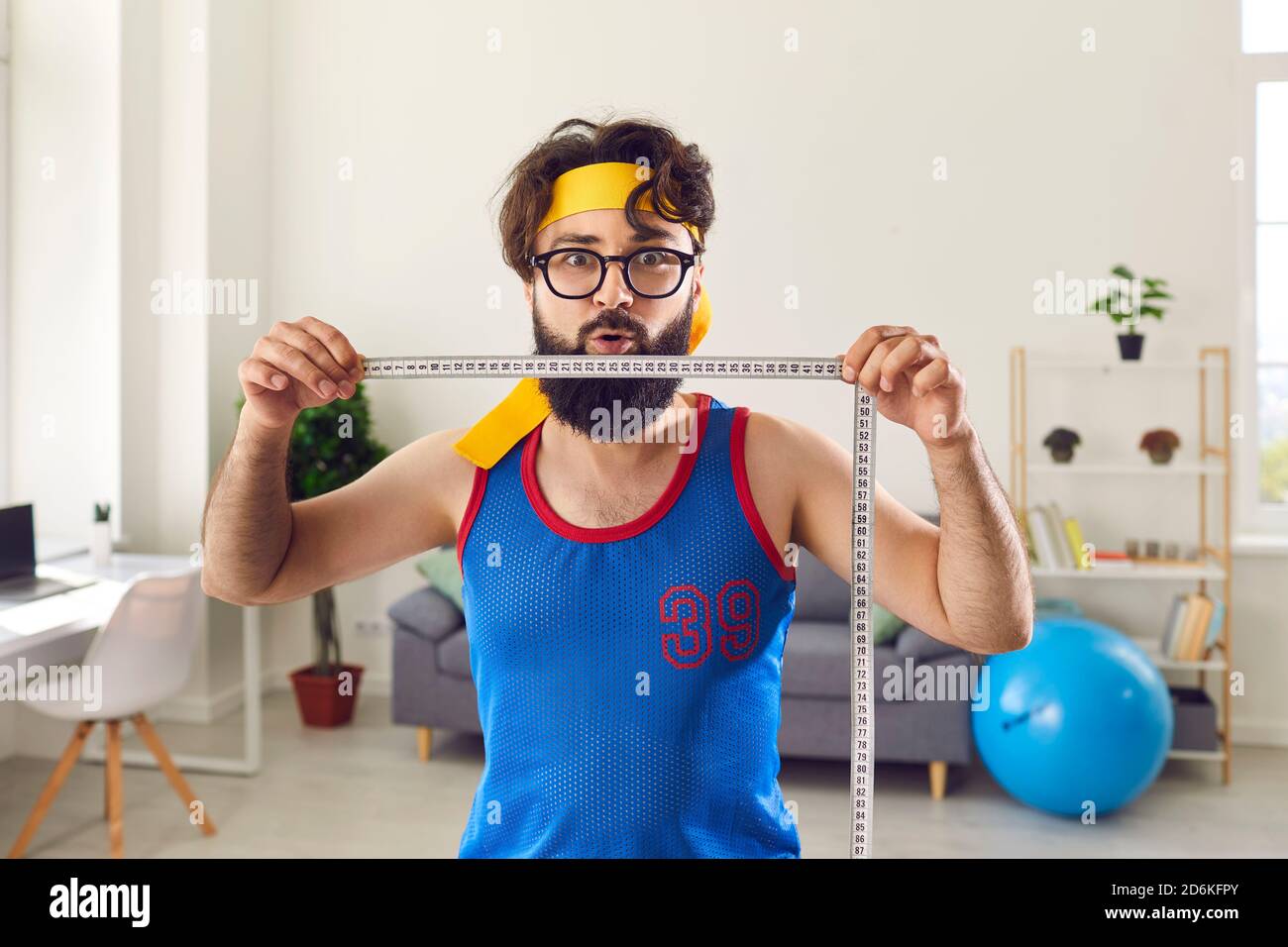 Lustige junge Mann hält Maßband und demonstriert erstaunliche Gewicht  Schadenergebnis Stockfotografie - Alamy