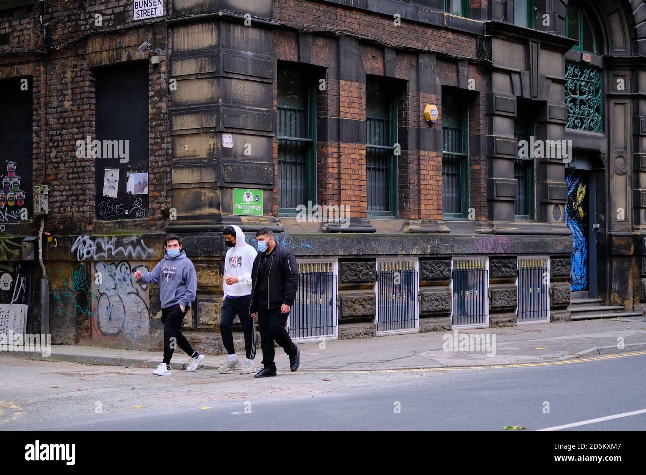 Manchester / Vereinigtes Königreich - 17. Oktober 2020: Drei junge Männer mit Gesichtsmasken in der Manchesters Street. Stockfoto