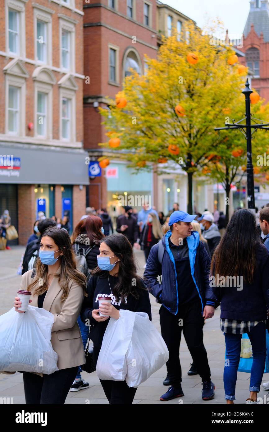 Manchester / Großbritannien - 17. Oktober 2020: Manchester Einkaufsstraße während Pandemie. Junge zwei Frauen tragen Gesichtsmasken und halten die Ladentin Stockfoto