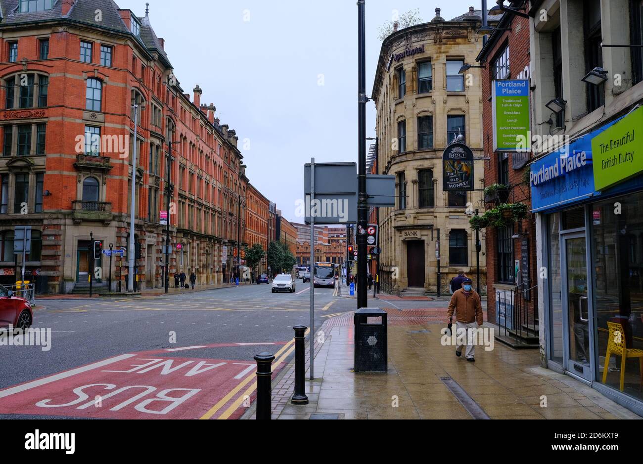 Manchester / Vereinigtes Königreich - 17. Oktober 2020: Mann im Gesicht Abdeckung in der leeren Straße von Manchester mit unverwechselbarer Stadtarchitektur gesehen. Stockfoto