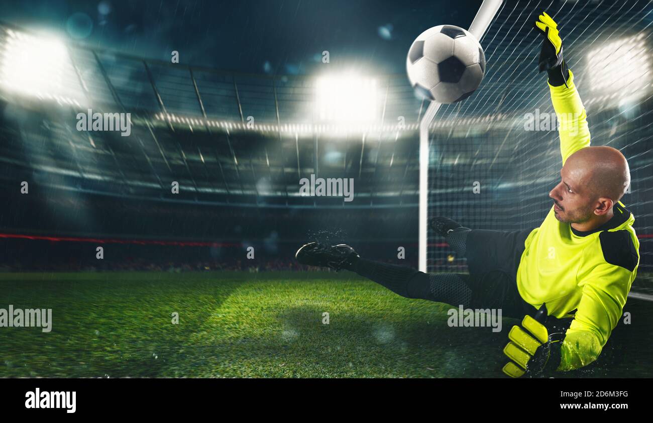 Fußball-Torwart, in fluoreszierender Uniform, das macht eine große sparen und vermeidet ein Tor im Stadion Stockfoto