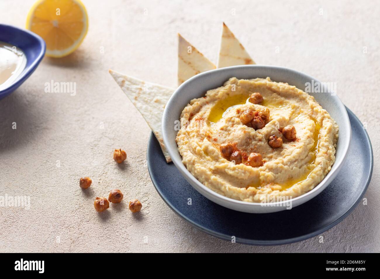 Klassischer Hummus in Schale mit Kichererbsen, Olivenöl und Gewürzen. Stockfoto