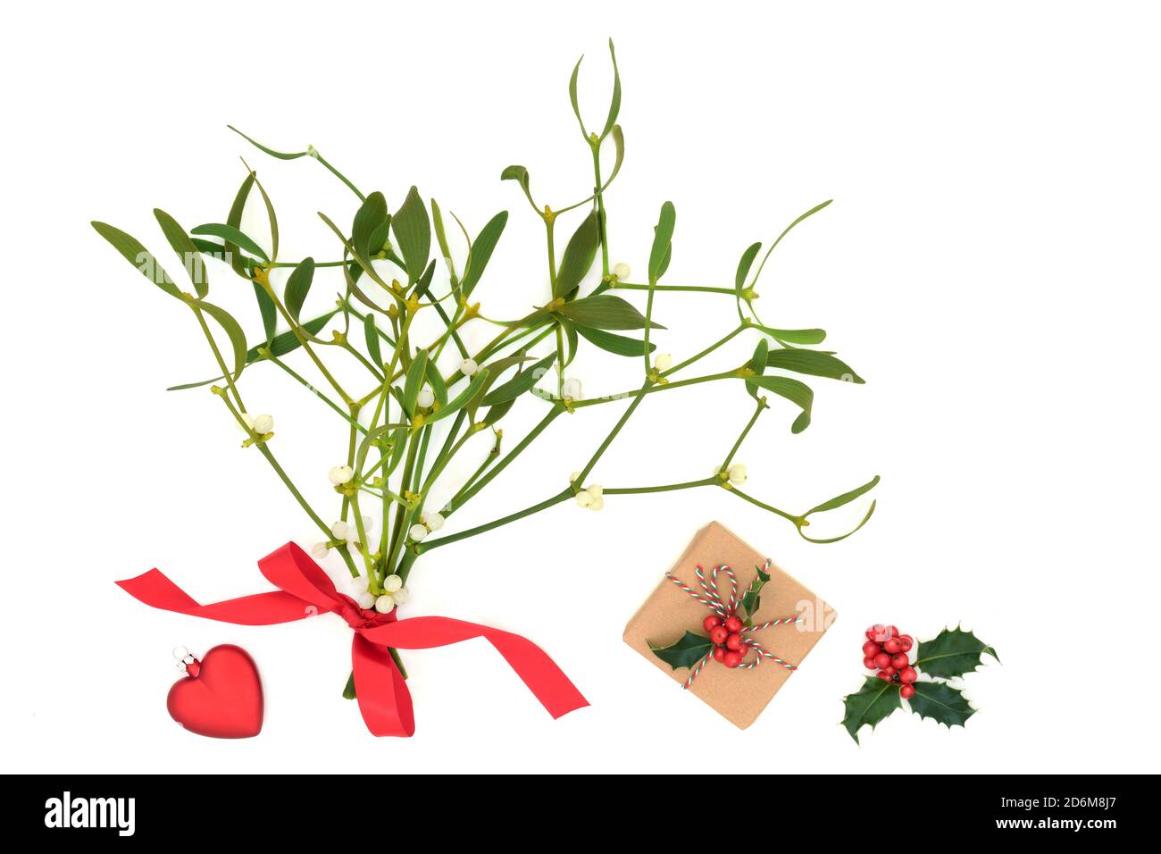 Weihnachtsromantik-Konzept mit Mistel, roter Herzkugel, Winterstachelbeere & Geschenkbox mit umweltfreundlichem braunem Geschenkpapier auf weißem Hintergrund. Stockfoto