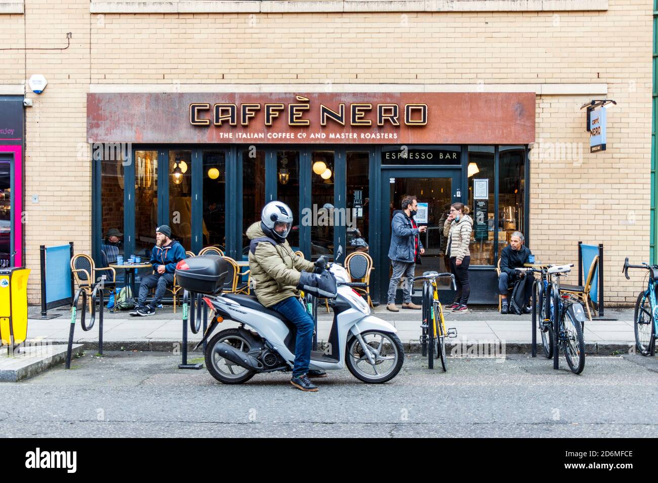 Kunden, die außerhalb des Coffeeshops Caffe Nero in der Jamestown Road saßen und sich während der Coronavirus-Pandemie sozial distanzierten, Camden Town, London, Großbritannien Stockfoto
