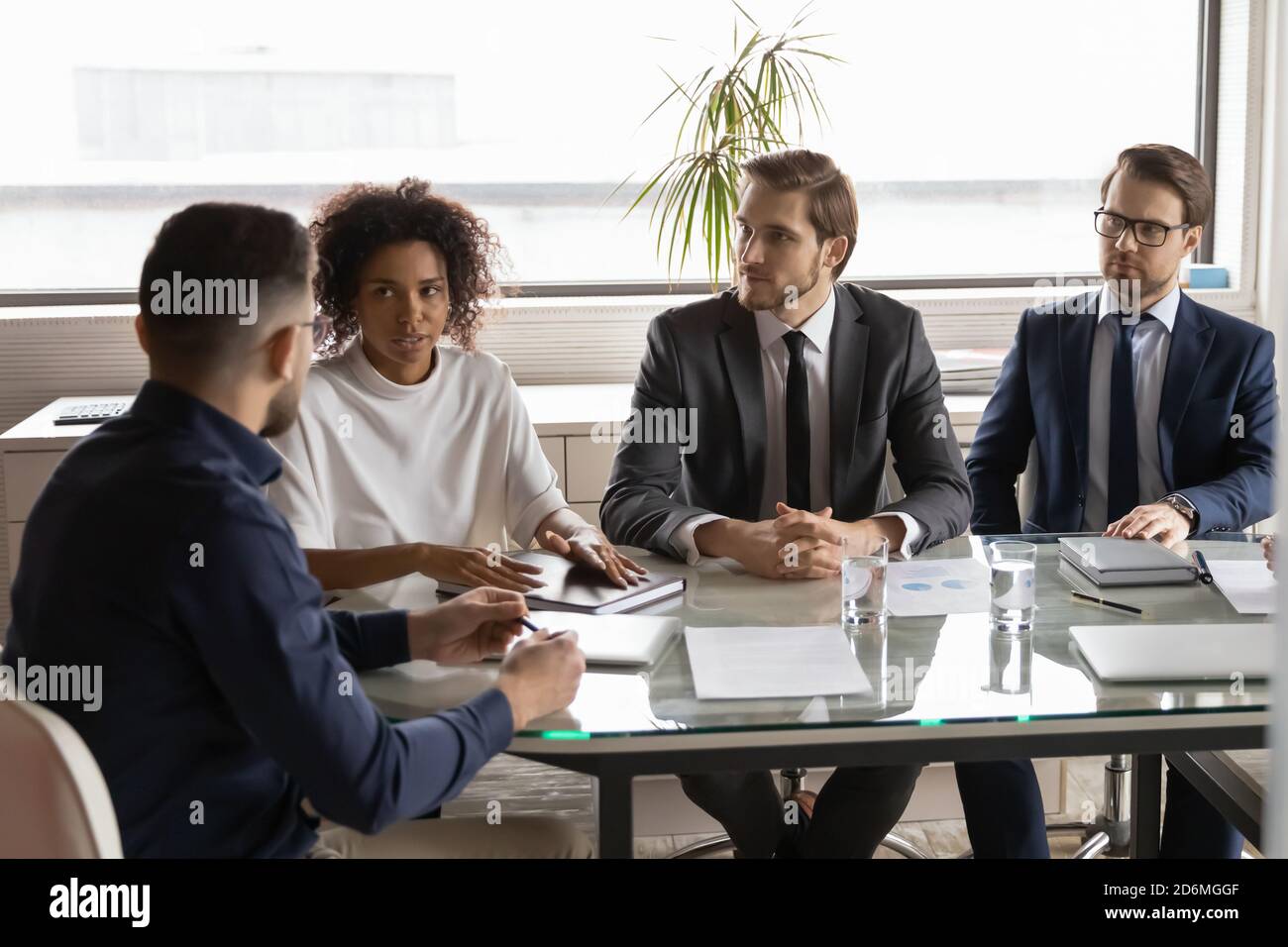 Konzentrierte junge multirassische Geschäftsleute Partner, die Verhandlungen treffen. Stockfoto