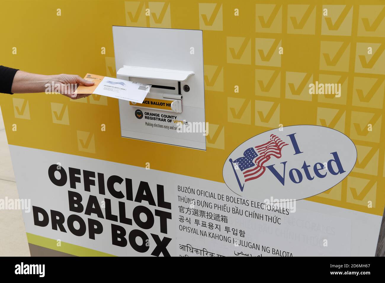 IRVINE, KALIFORNIEN - 18 Okt 2020: Frau, die in einer offiziellen Wahlurne in Orange County, Kalifornien, Post in den Stimmzettel legt. Stockfoto