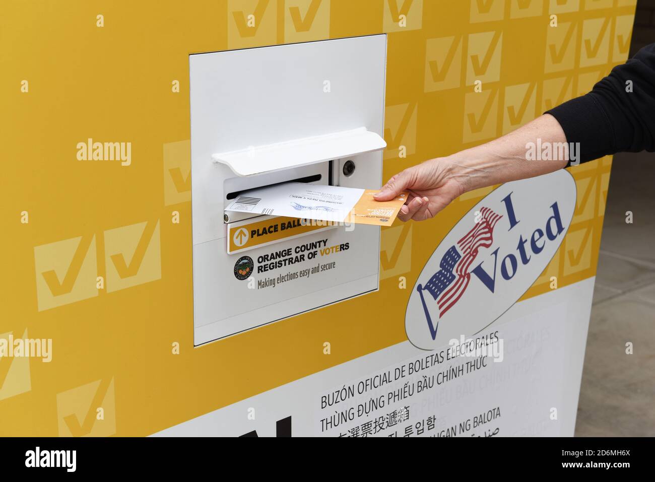 IRVINE, KALIFORNIEN - 18 Okt 2020: Frau, die in einem öffentlichen Park, Irvine, Orange County, Kalifornien, eine Briefwahl in einer offiziellen Wahlurne ablegt. Stockfoto