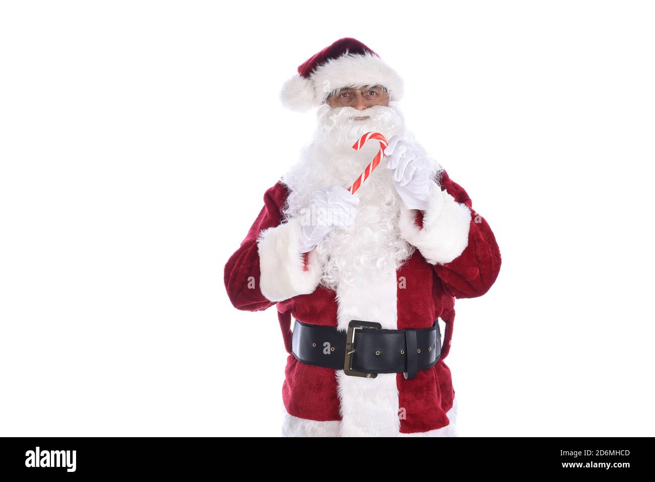 Älterer Mann in traditioneller Weihnachtsmann-Tracht mit einem Zuckerrohr in beiden Händen. Isoliert auf Weiß. Stockfoto
