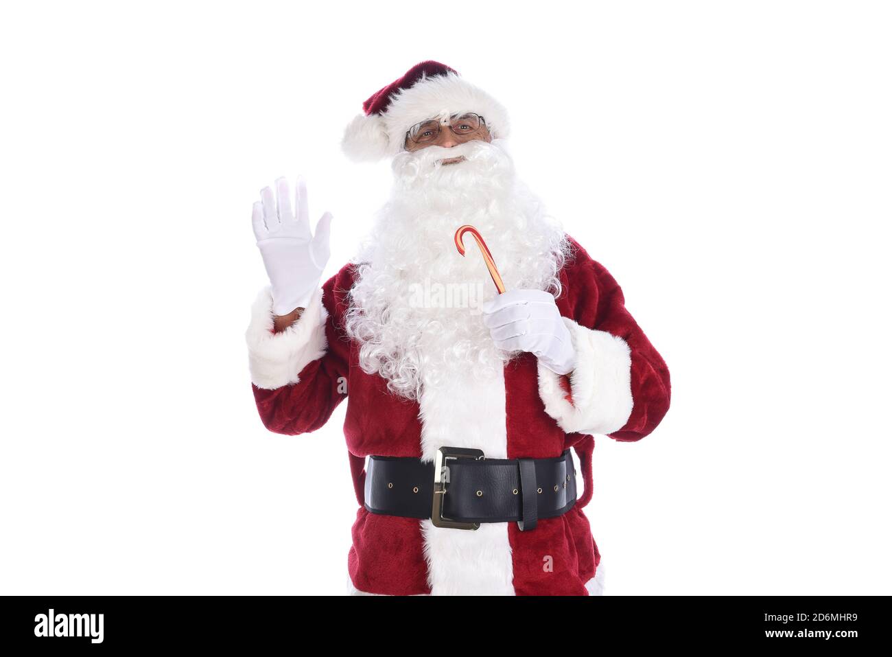 Senior Mann in traditionellen Weihnachtsmann Kostüm hält einen Zuckerrohr in der einen Hand und winkt mit der anderen. Isoliert auf Weiß. Stockfoto