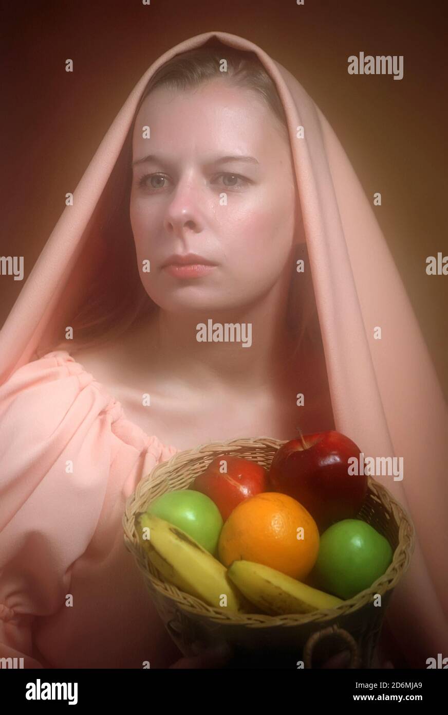 Erwachsene weibliche Porträt mit einem Korb von gesunden Früchten einschließlich Bannana-Apfel Stockfoto