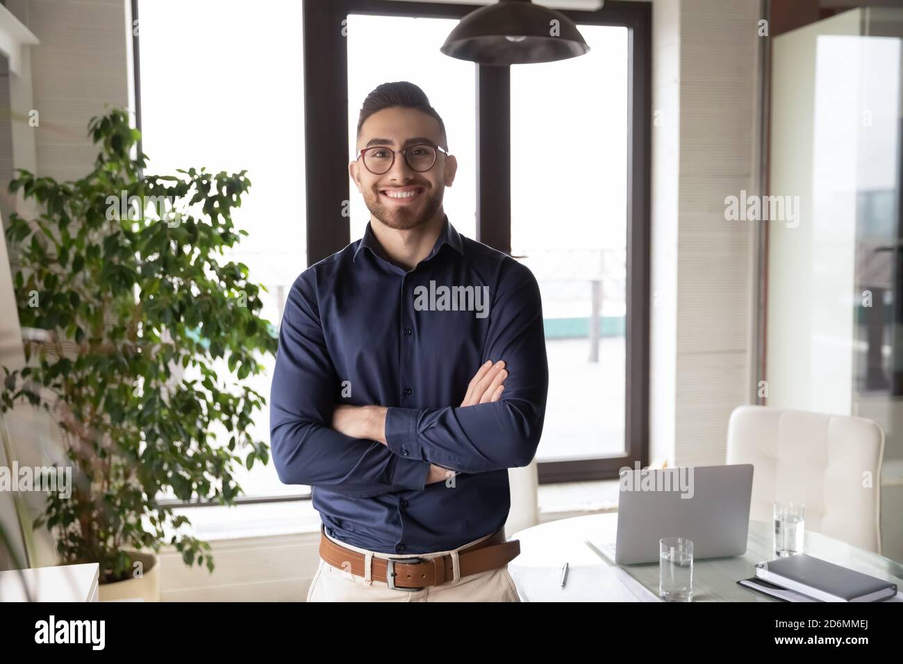 Porträt eines glücklichen jungen arabischen Geschäftsmannes, der im Büro steht. Stockfoto