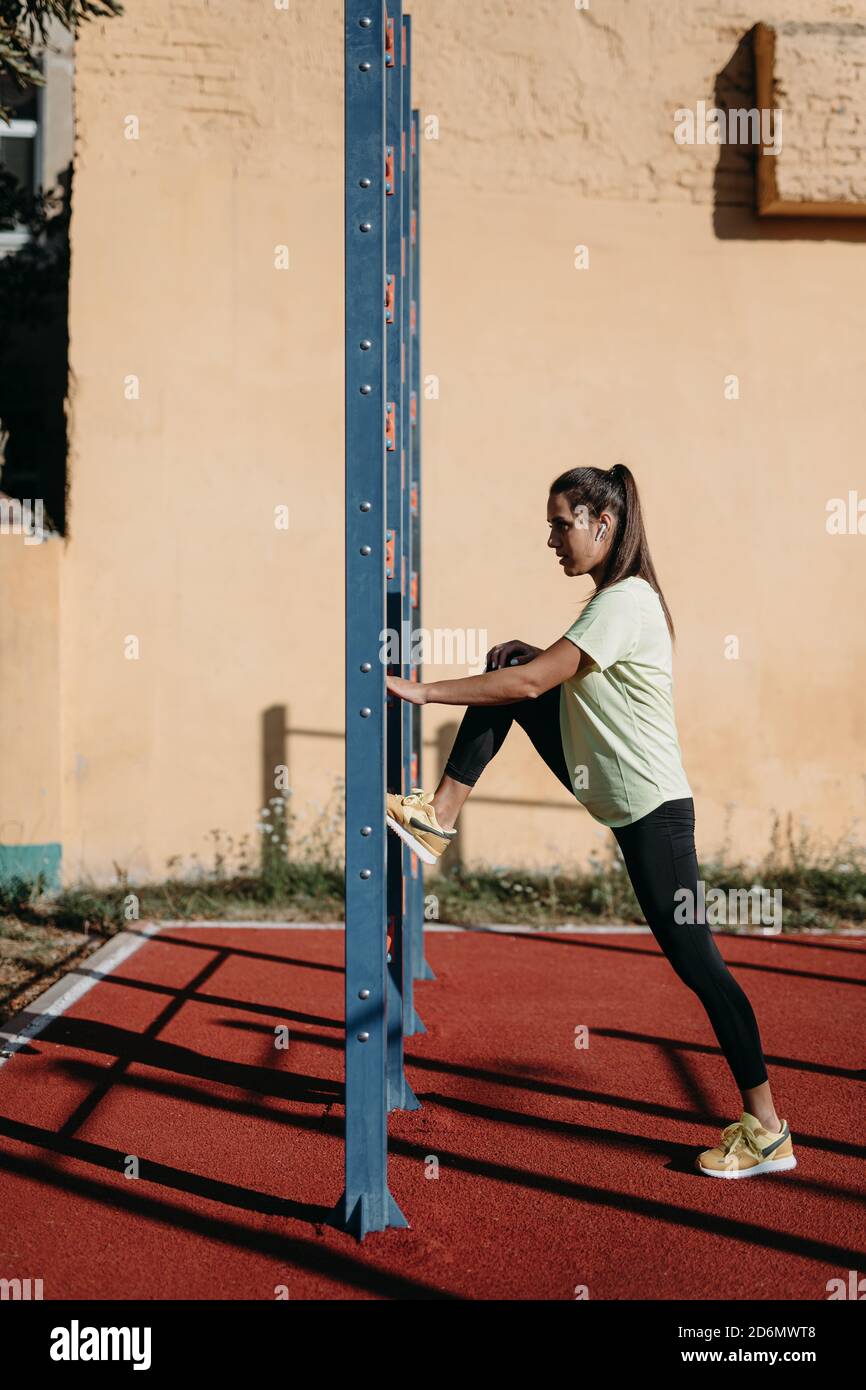 Schöne sportliche Hündin im Aktivewear Training in der Nähe der Wandbar Stockfoto