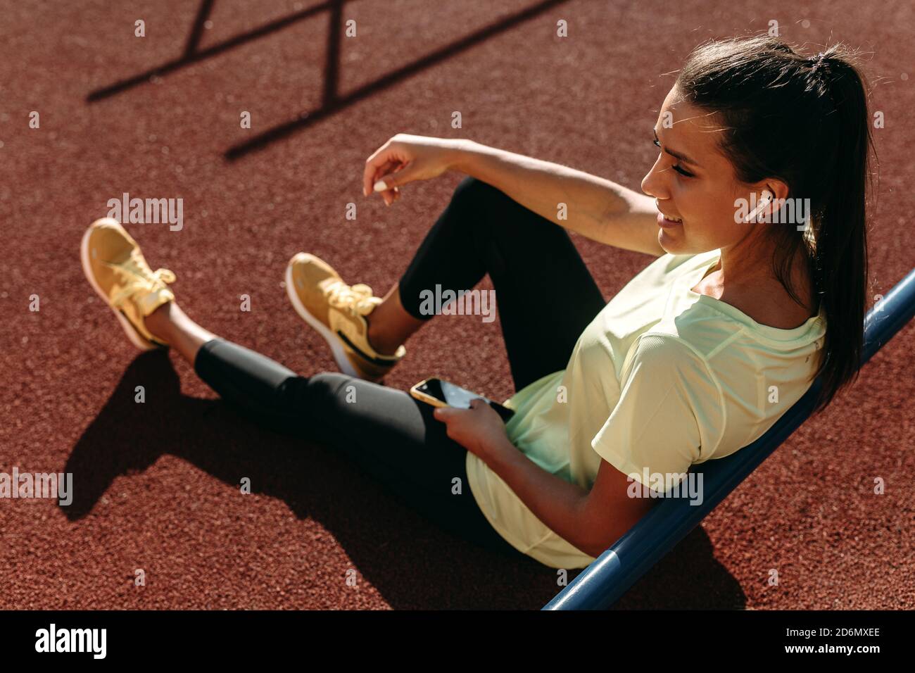 Sportliche Frau, die nach dem Training Musik auf dem Smartphone hört Stockfoto