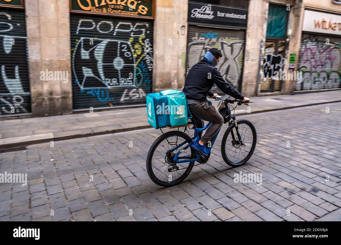 Ein Deliveroo-Bote ist auf der Calle Ferrán in der Nähe der Plaza Sant Jaume im Umlauf, Um Hauslieferungen zu machen.die Aktivität rund um Essen zum Mitnehmen hat in Barcelona aufgrund der Verordnung der katalanischen Regierung, die kommerzielle Tätigkeit von Bars und Restaurants für 15 Tage wegen der Zunahme der Ansteckung von Covid19 zu schließen, zugenommen. Stockfoto