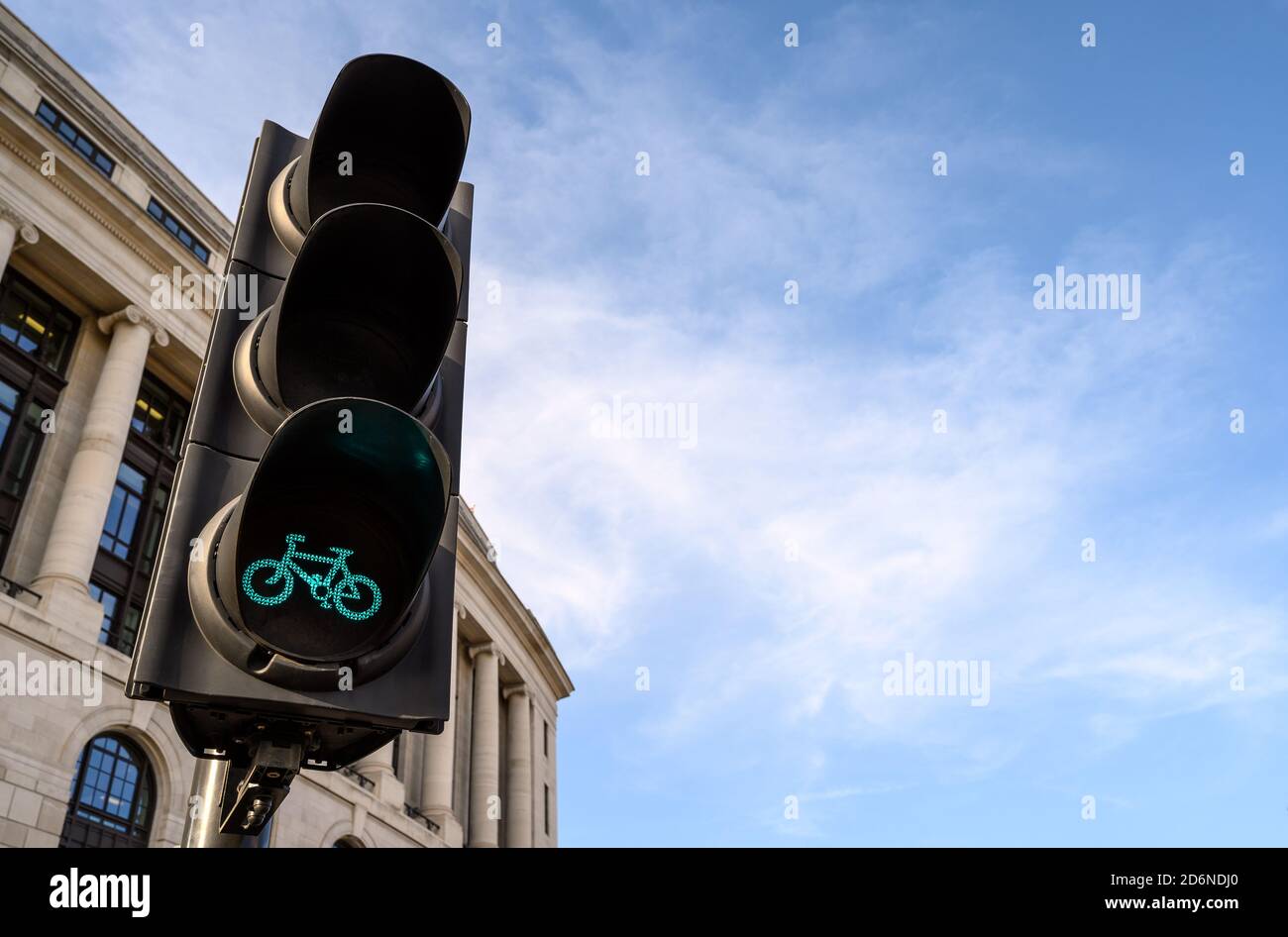 Eine Fahrradampel in London, Großbritannien. Die Ampel ist grün zum Radfahren. Altes Gebäude im Hintergrund. Blauer Himmel mit weißen Wolken ist Kopierraum. Stockfoto