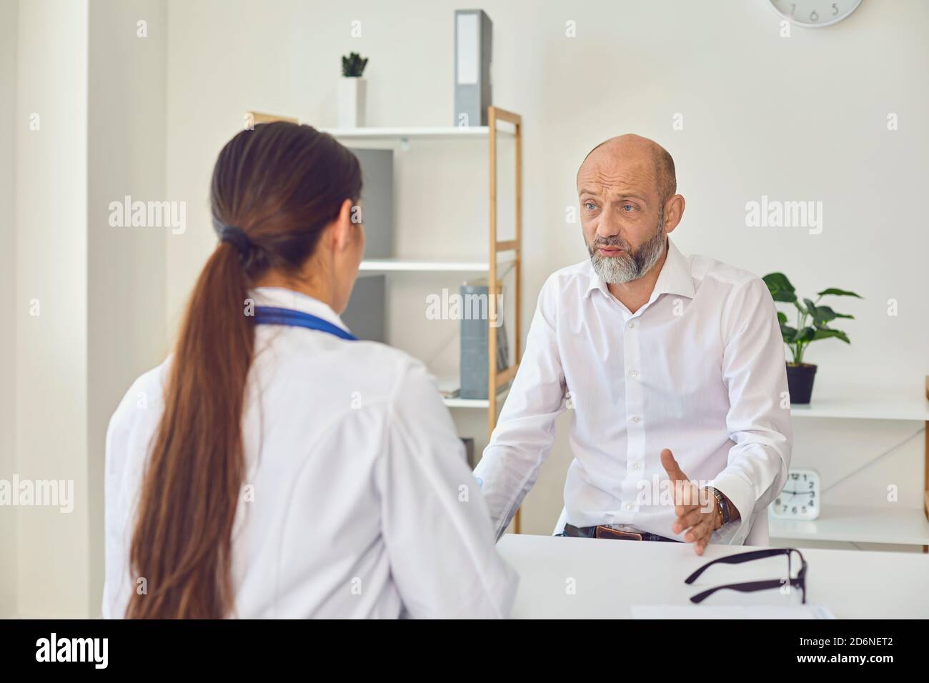 Ein Mann mittleren Alters spricht mit einem Arzt im Büro. Ärztliche Beratung Diagnose Rezept in einem Krankenhaus Stockfoto