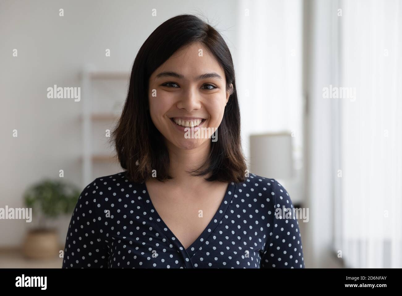 Profilbild einer lächelnden asiatischen Frau, die drinnen posiert Stockfoto