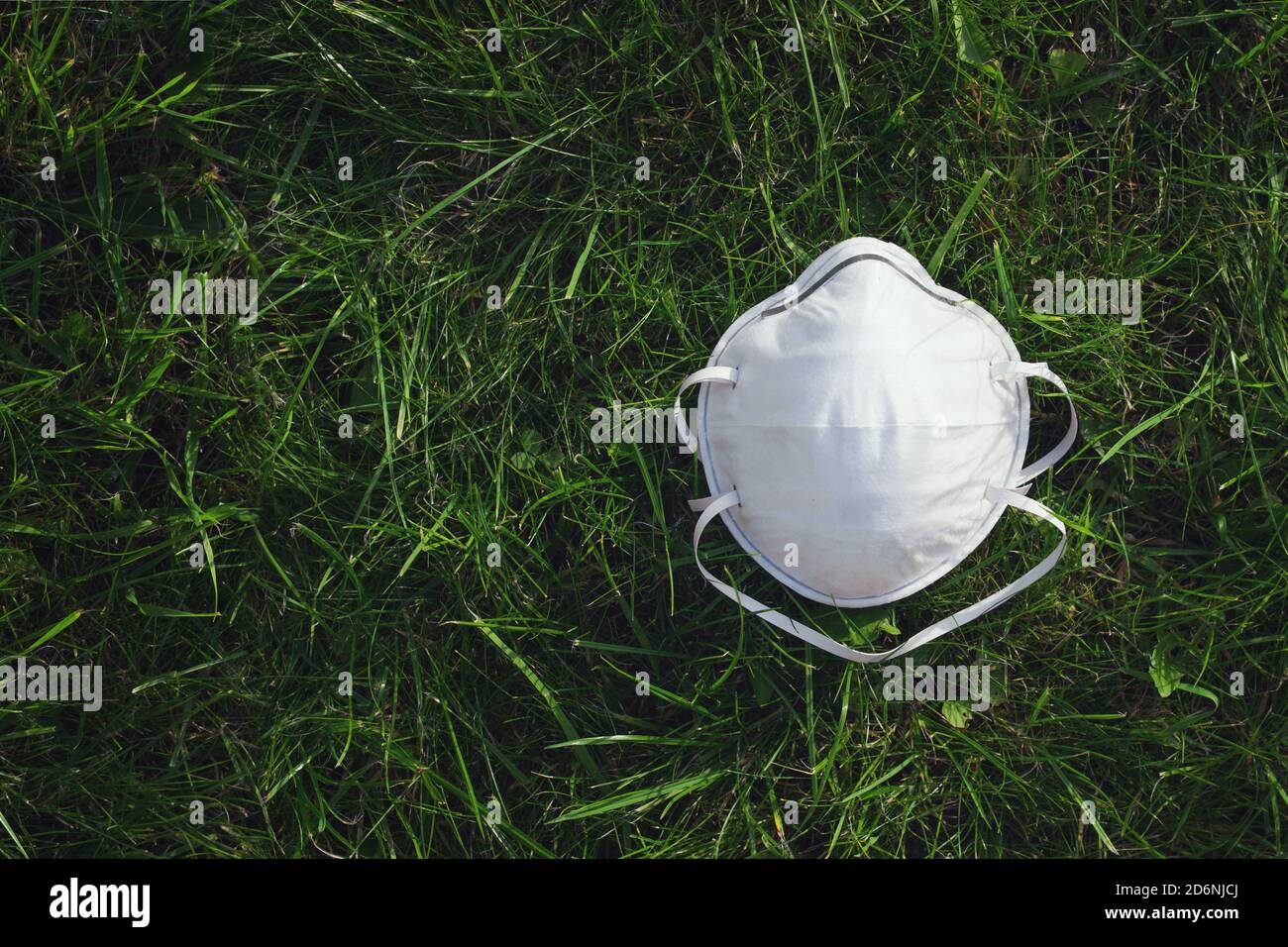 Schützende medizinische Maske auf Gras, Epidemie von Coronavirus covid-19. Coronavirus-Epidemien Und Das Risiko Einer Biologischen Kontamination Stockfoto