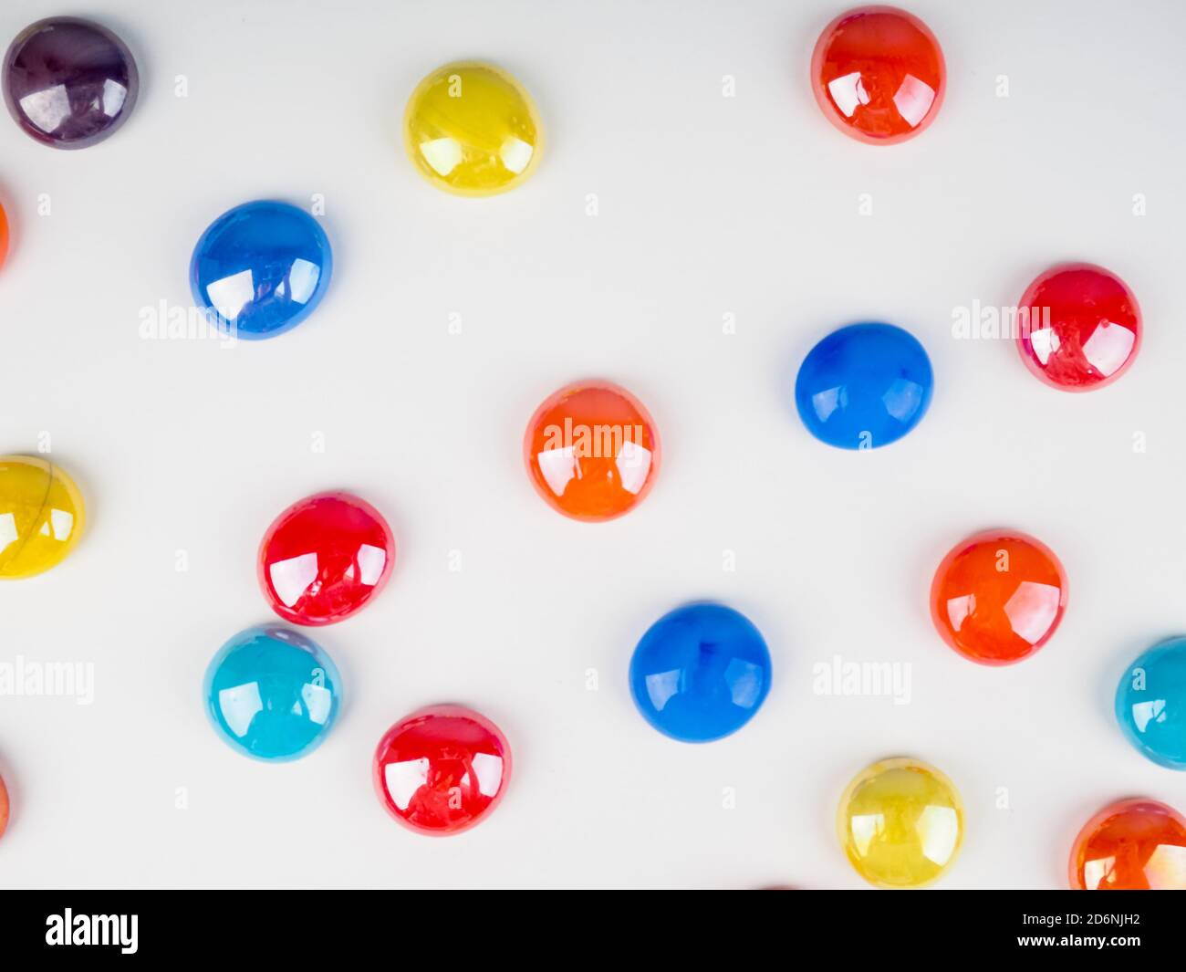 Glänzende bunte Steinkugeln auf weißem Hintergrund als Hintergrund. Abstrakt holyday Hintergrund der bunten Glasperlen Stein Kieselsteine auf weißem Hintergrund Stockfoto