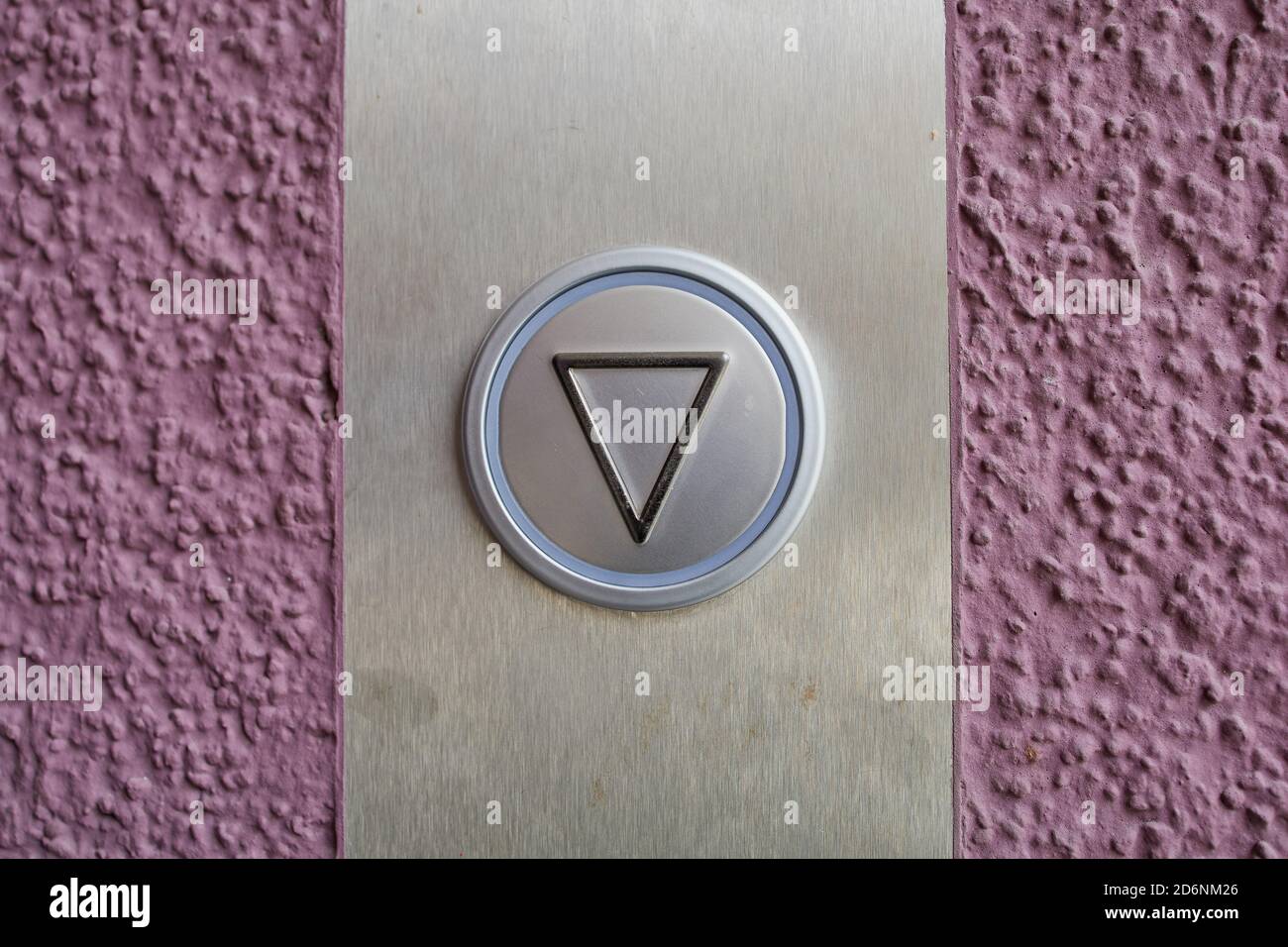 Nahaufnahme eines Aufzugsknopfes an einer violetten Wand Stockfoto