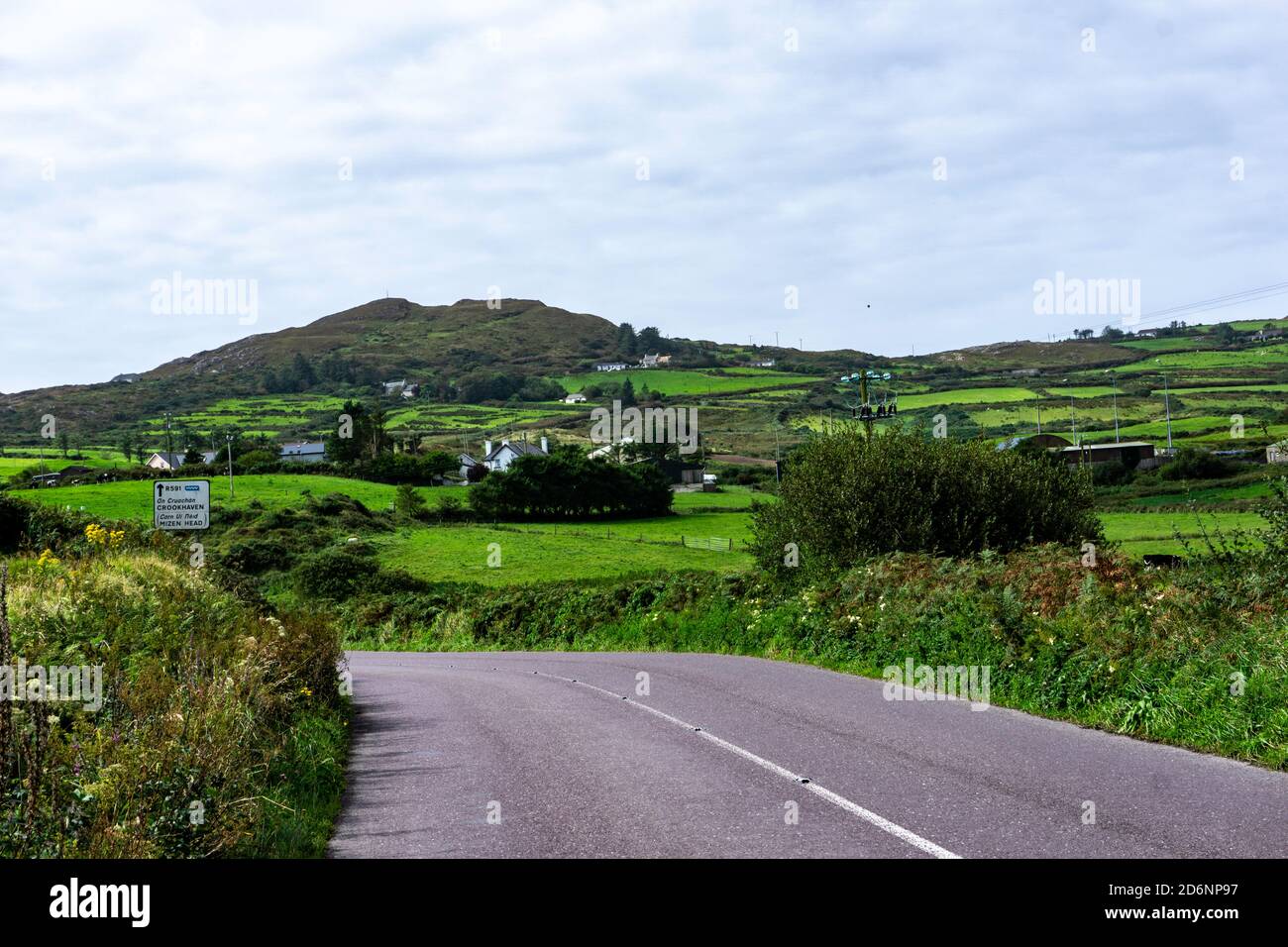 Die wunderschöne Landschaft von West Cork, County Cork, Irland. Das Straßenschild ist in Richtung Crookhaven und Mizen Head. Stockfoto