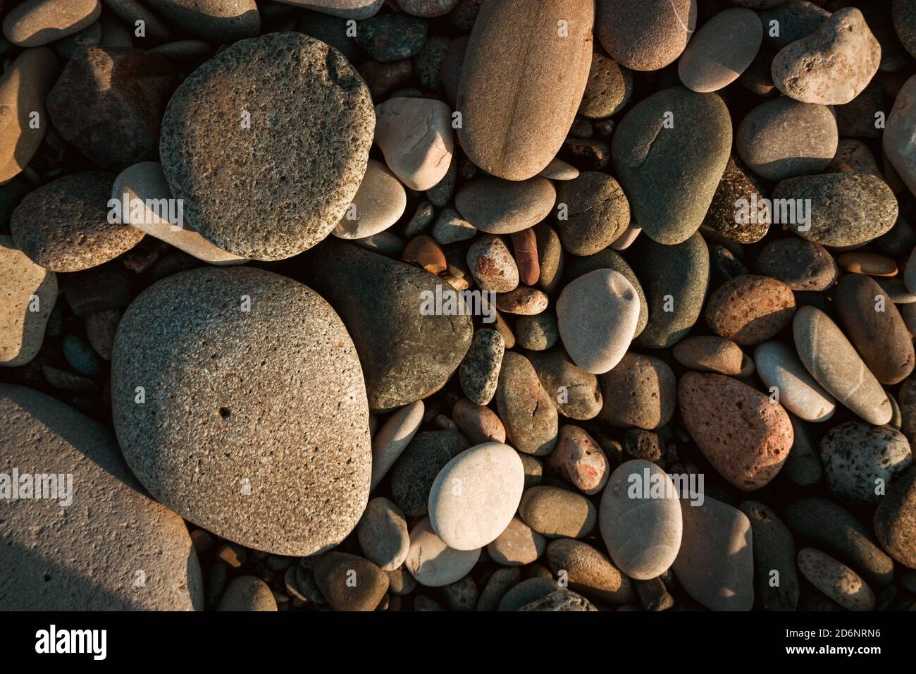 Steinkiesel am Strand als Hintergrund Stockfoto