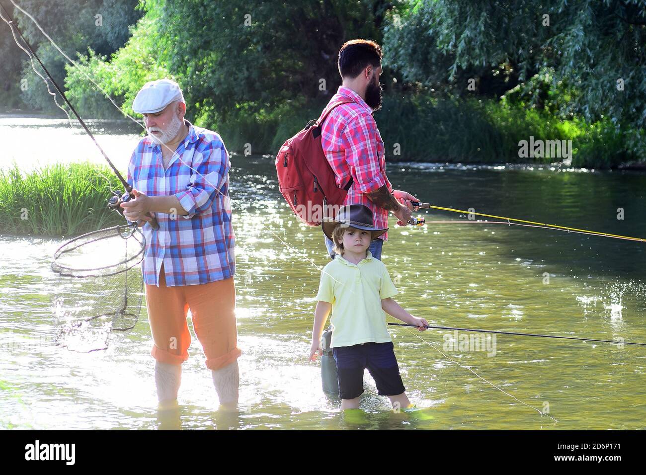 Großvater und Enkelkind. Großvater mit Sohn und Enkel Spaß im Fluss. Sommertag. Hobby und sportliche Aktivität. Stockfoto