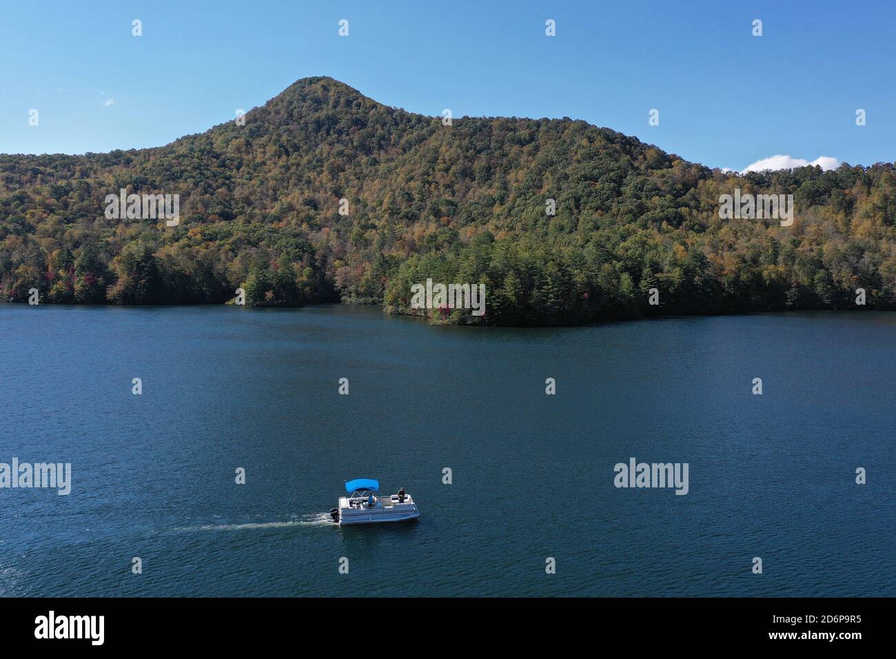 Luftbild von Funnel Top Mountain und Lake Santeetlah, North Carolina in Herbstfarbe mit Ponton Boot im Vordergrund. Stockfoto