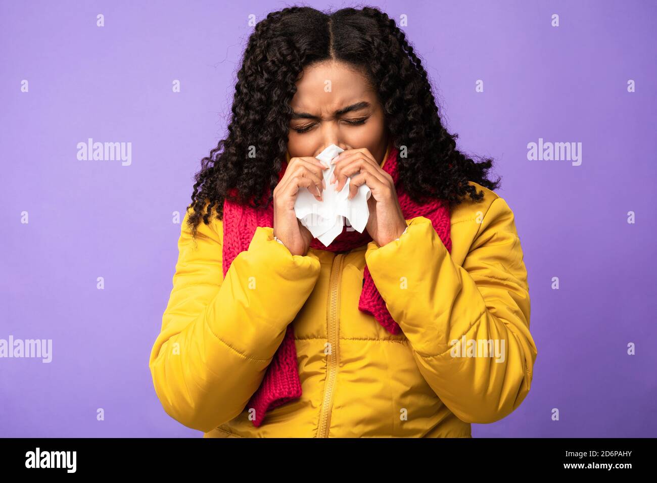 Krank Afrikanische Frau Blasen Nase Niesen In Gewebe, Lila Hintergrund Stockfoto