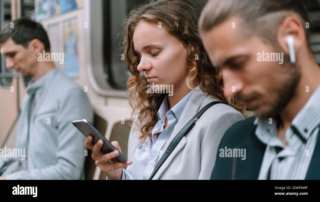 Passagiere mit Smartphones im U-Bahn-Auto . Stockfoto