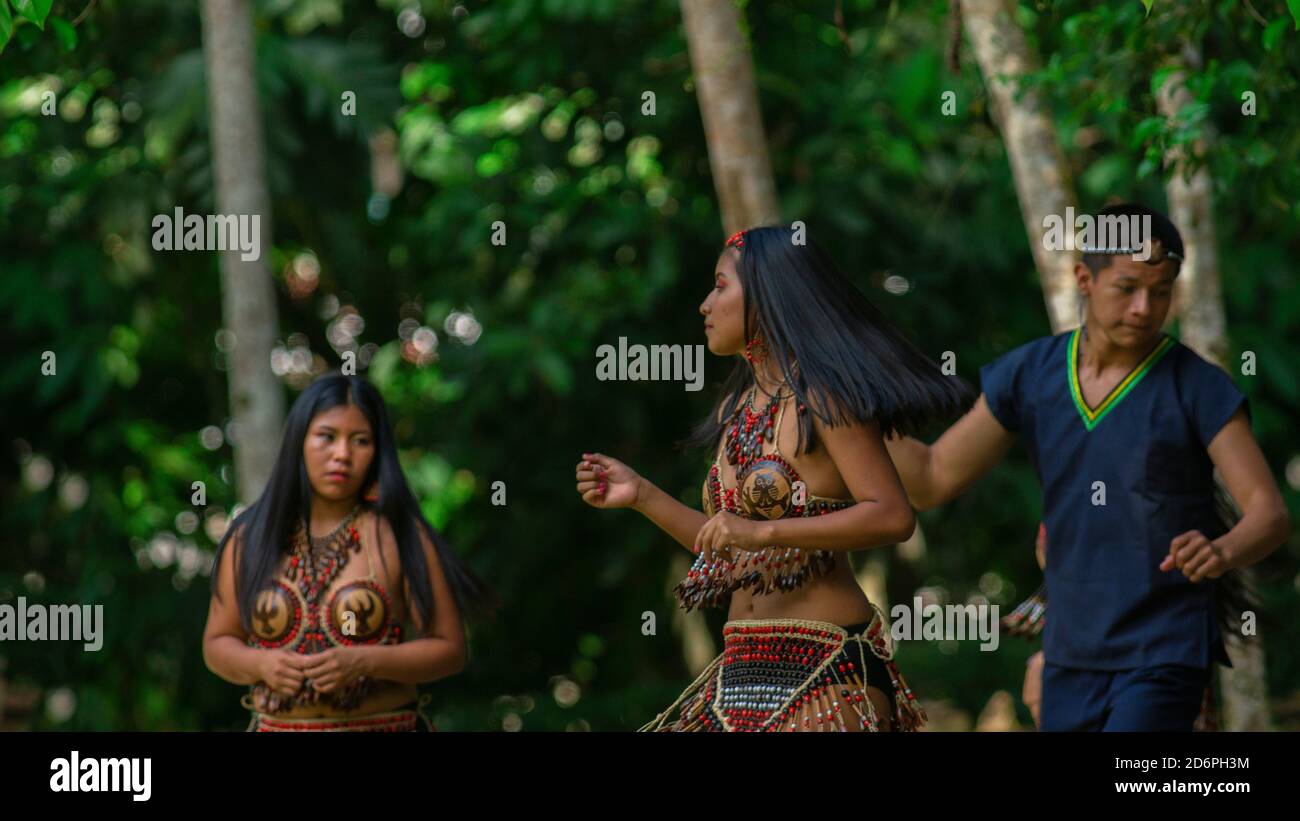 Tena, Napo / Ecuador - Oktober 10 2020: Gruppe von Jugendlichen, die mit typischen Kostümen der ethnischen Gruppen des ecuadorianischen Amazonas in einem Park tanzen Stockfoto