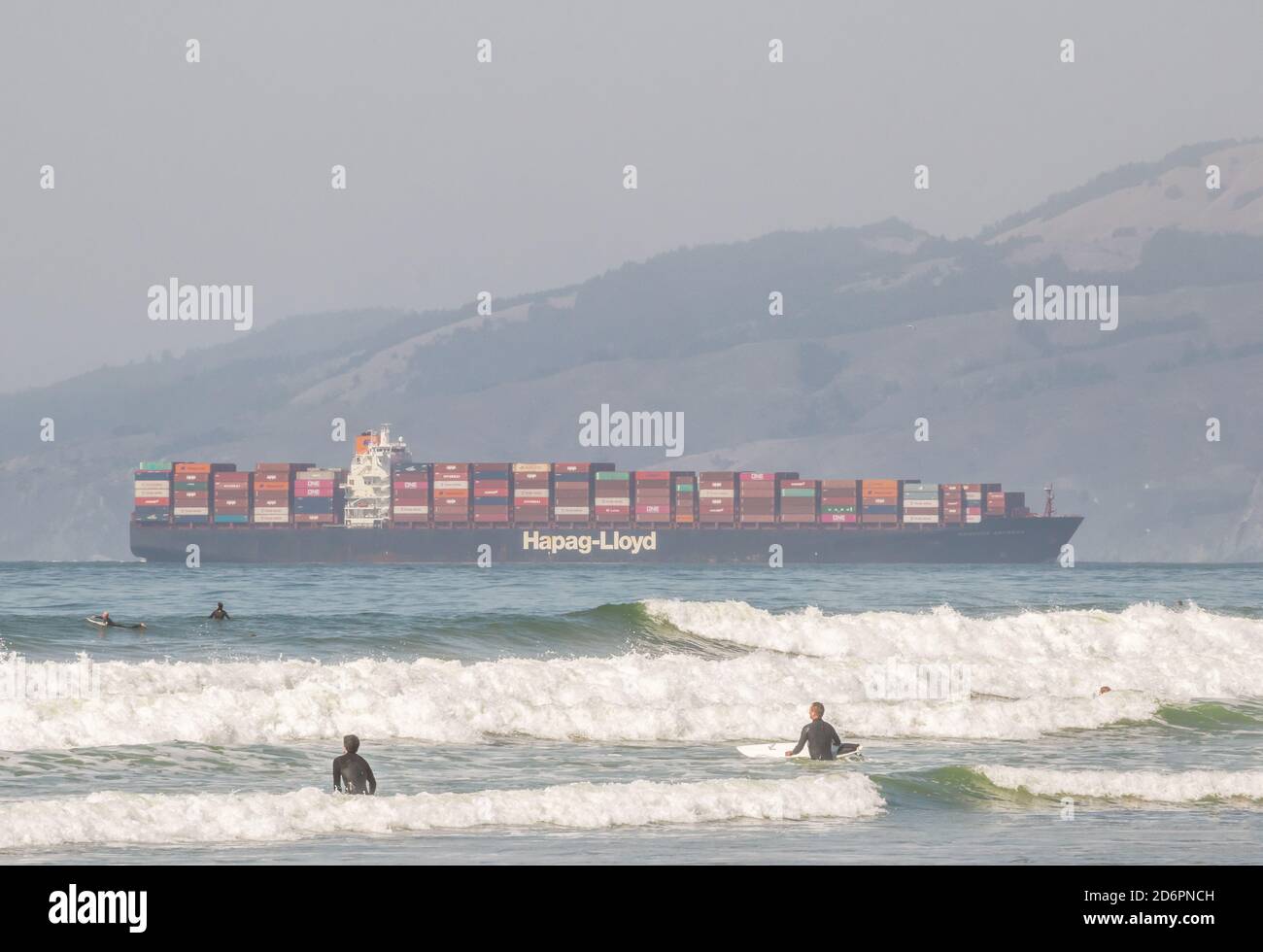 San Francisco, Kalifornien - 27. September 2020: Menschen genießen Ocean Beach mit einem Frachtschiff im Hintergrund Stockfoto