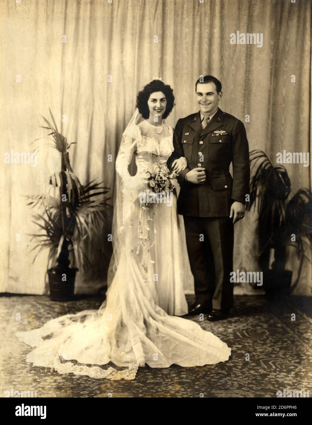 1946 Ca, BRESCIA, ITALIEN: Die Ehe von BETTY & CHARLIE, sie war aus der norditalienischen Stadt Brescia und er aus DEN VEREINIGTEN STAATEN von AMERIKA während des Militärdienstes kurz nach dem Zweiten Weltkrieg in Italien. Das Paar traferred sofort in US - NOZZE - abito da SPOSA - HOCHZEITSKLEID PARTY - BRAUT - cerimonia - FOTO STORICHE - GESCHICHTE FOTOS - XX JAHRHUNDERT - NOVECENTO - coppia di sposi - militärische Uniform - uniforme vestito militare - Thulle - Tüll - strascico - FAMIGLIA - FAMILIE - Marito e moglie - Ehefrau und Ehemann - Festa - Party - ricevimento - velo - Schleier - Blumen - fiori - f Stockfoto