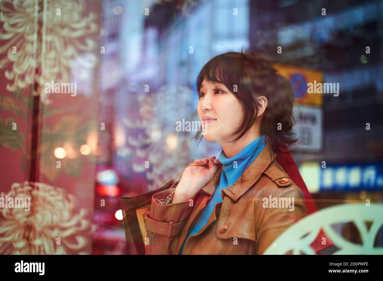Schöne junge asiatische Frau Shopper vor dem Geschäft stehen Fenster in der modernen Stadt Stockfoto
