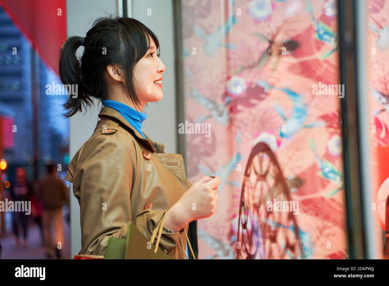 Schöne glücklich junge asiatische Frau Shopper Blick in Schaufenster In einer modernen Stadt Stockfoto
