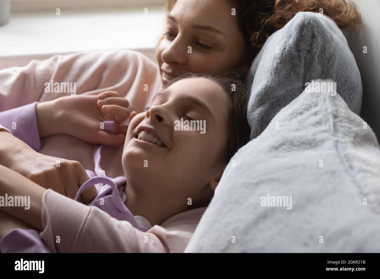 Glückliche Mutter und Teenager-Tochter entspannen zu Hause träumen Stockfoto