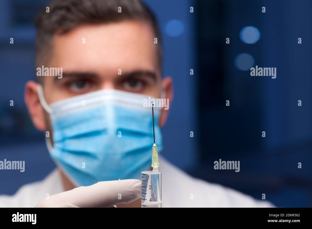 Nahaufnahme des Arztes mit medizinischer Maske Vorbereitung einer Spritze für Impfung - Fokus auf die Nadel Stockfoto