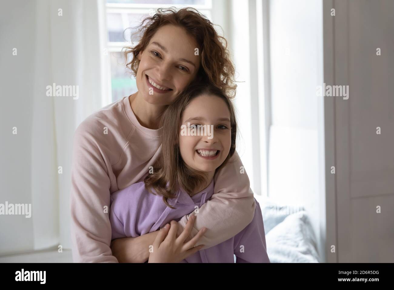 Portrait von glücklich Mutter und teen Tochter Umarmung Stockfoto