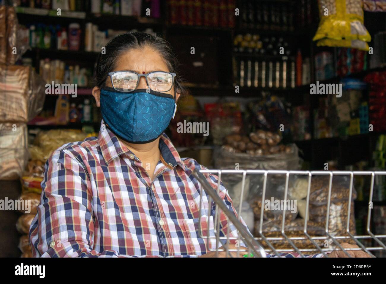 Dehradun, Uttarakhand/Indien-Oktober 14 2020:EINE Ladenbesitzerin mit Gesichtsmaske wartet auf Kunden in der Corona-Pandemie in Indien. Hochwertige Fotos Stockfoto
