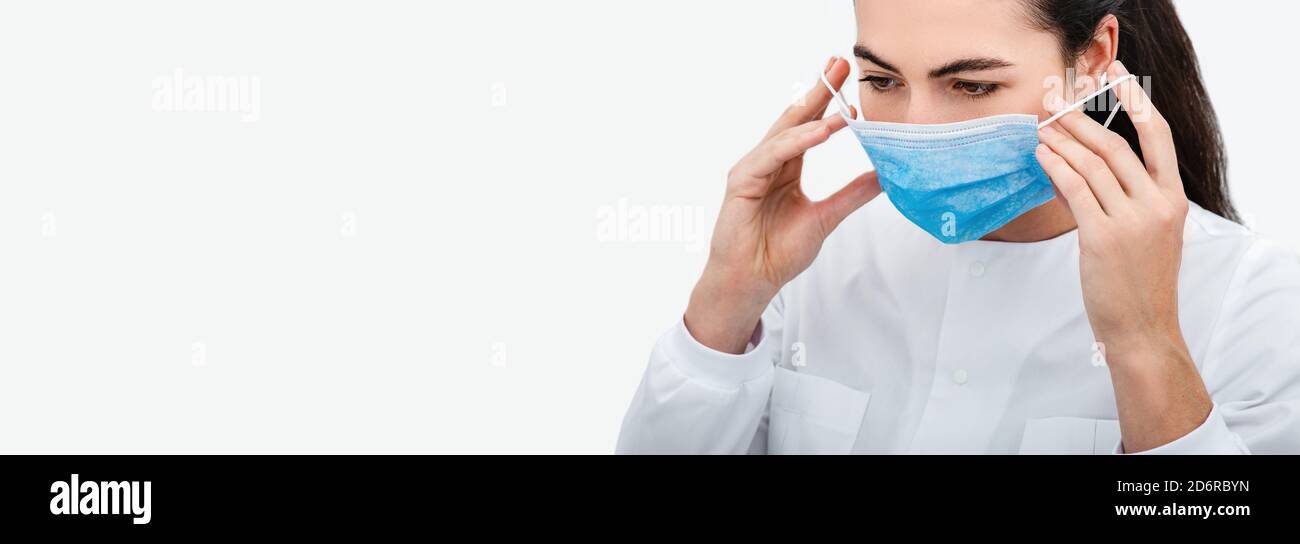 Nahaufnahme des Gesichts einer Ärztin, während sie in einem Krankenhaus eine Schutzmaske aufsetzt. Schutzmittel während einer globalen Pandemie Stockfoto