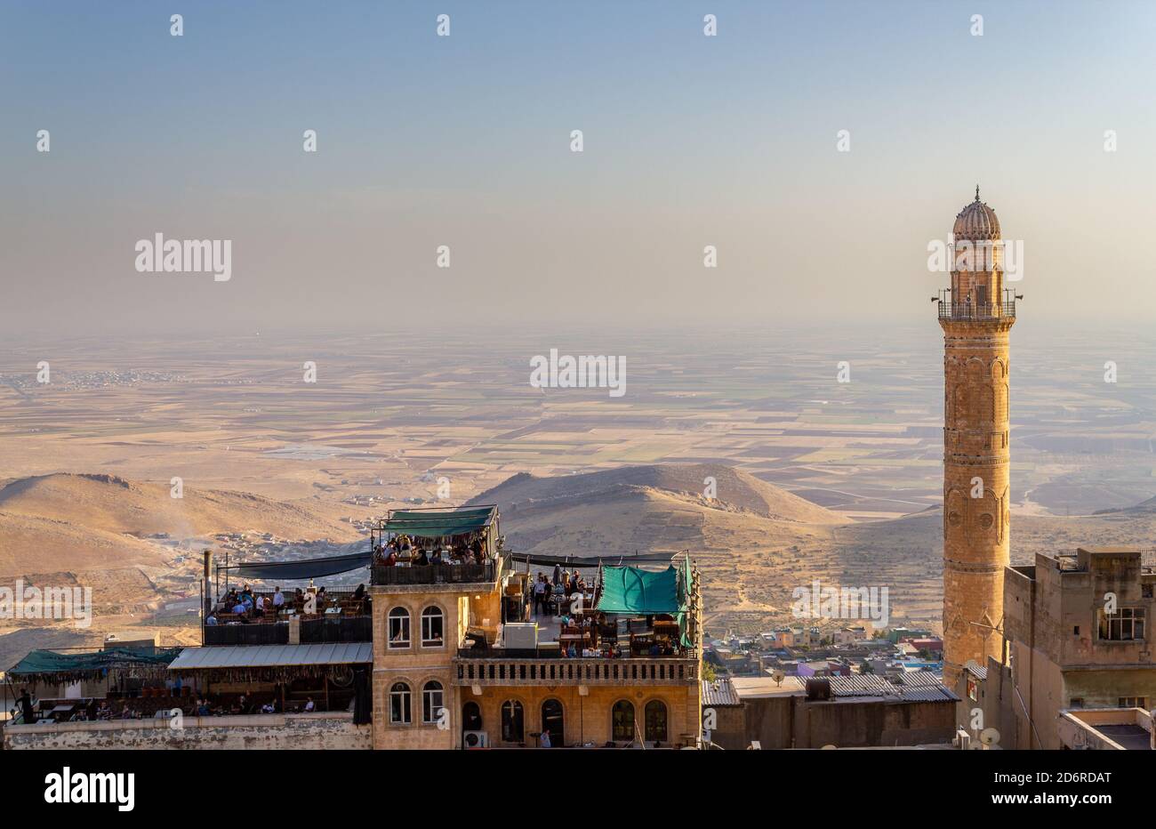 Mardin / Türkei - Oktober 10 2020: Mardin Ulu Cami Moschee Minarett und Menschen sitzen im Dachcafe, Mesopotamia Valley Blick Stockfoto
