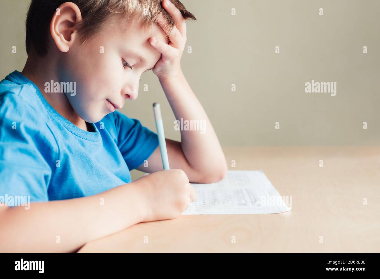 Seitenansicht zu niedlichen Jungen tun seine Hausaufgaben. Kind schreiben mit Bleistift. Vorschreiben Praxis Muster wie die Vorbereitung Hände für das Schreiben von Briefen Stockfoto