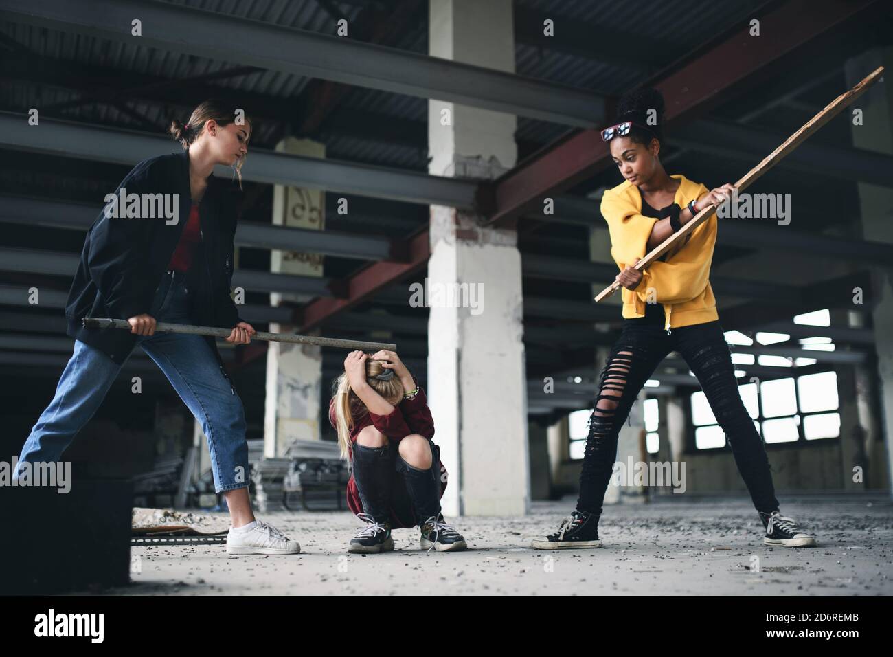 Teenager-Mädchen von Schlägern in verlassenen Gebäude, Bandengewalt und Mobbing Konzept angegriffen. Stockfoto