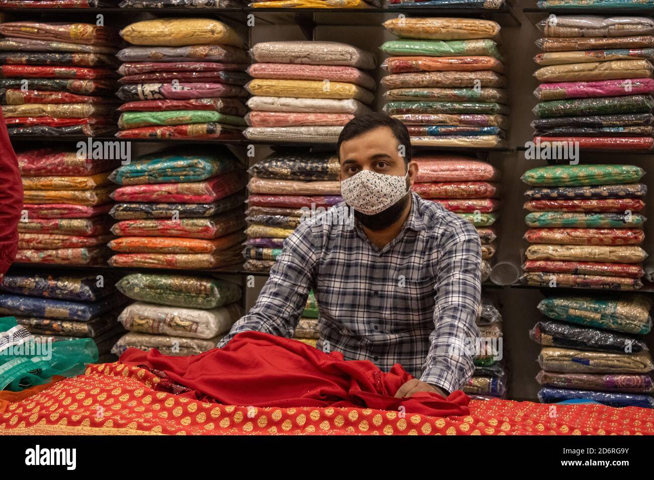 Dehradun, Uttarakhand/Indien-Oktober 14 2020:EIN Verkäufer sucht Kunden in Saree-Zentrum in Indien, trägt Gesichtsmaske wegen Corona Pandemie. . Hochwertige Fotos Stockfoto