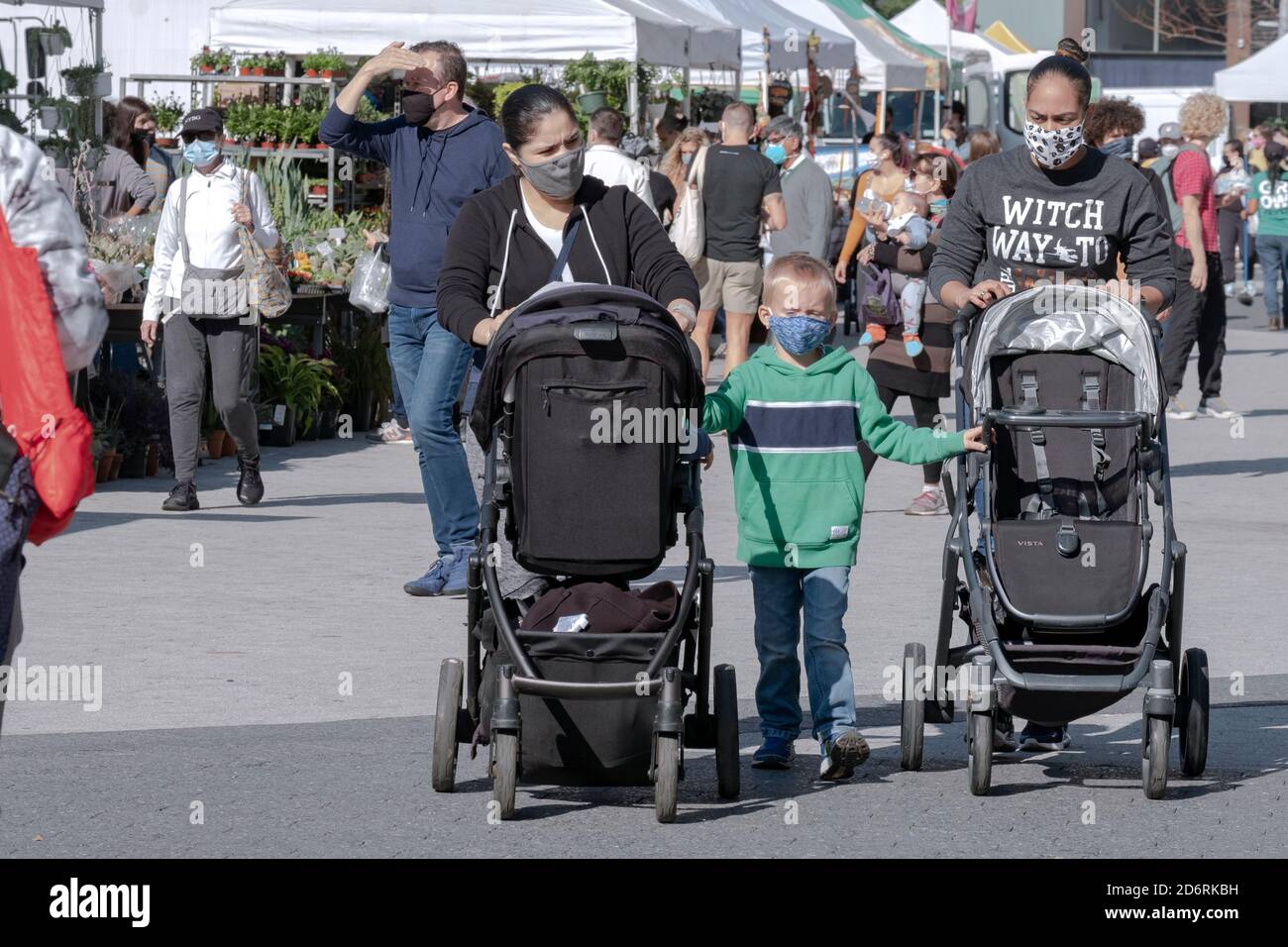 Zwei Frauen schieben Kinderwagen mit einem Kind hält an. Am Union Square Market, wo Masken erforderlich sind. In Manhattan, New York City. Stockfoto