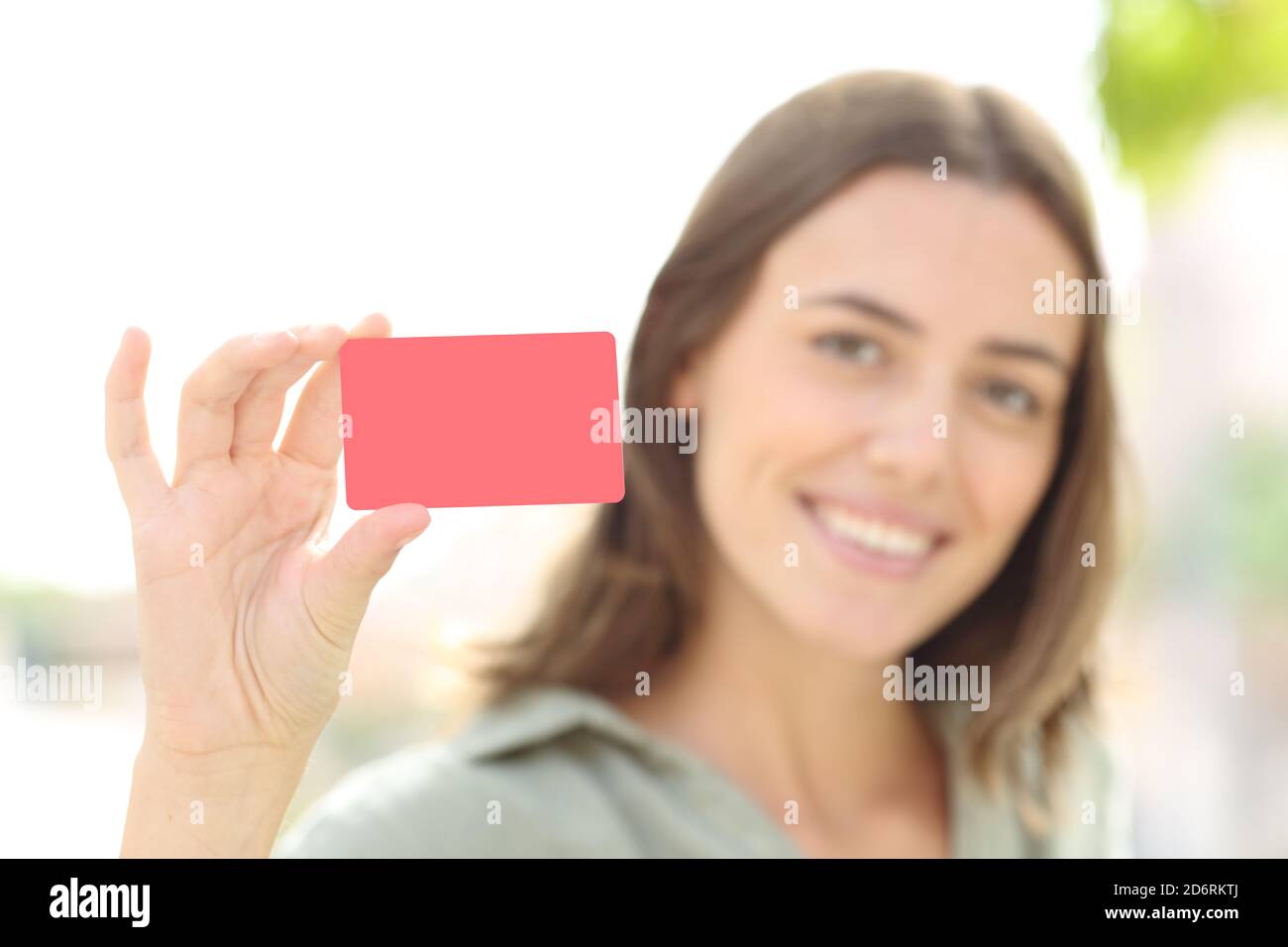 Eine glückliche Frau, die draußen auf der Straße eine leere Kreditkarte zeigte Stockfoto