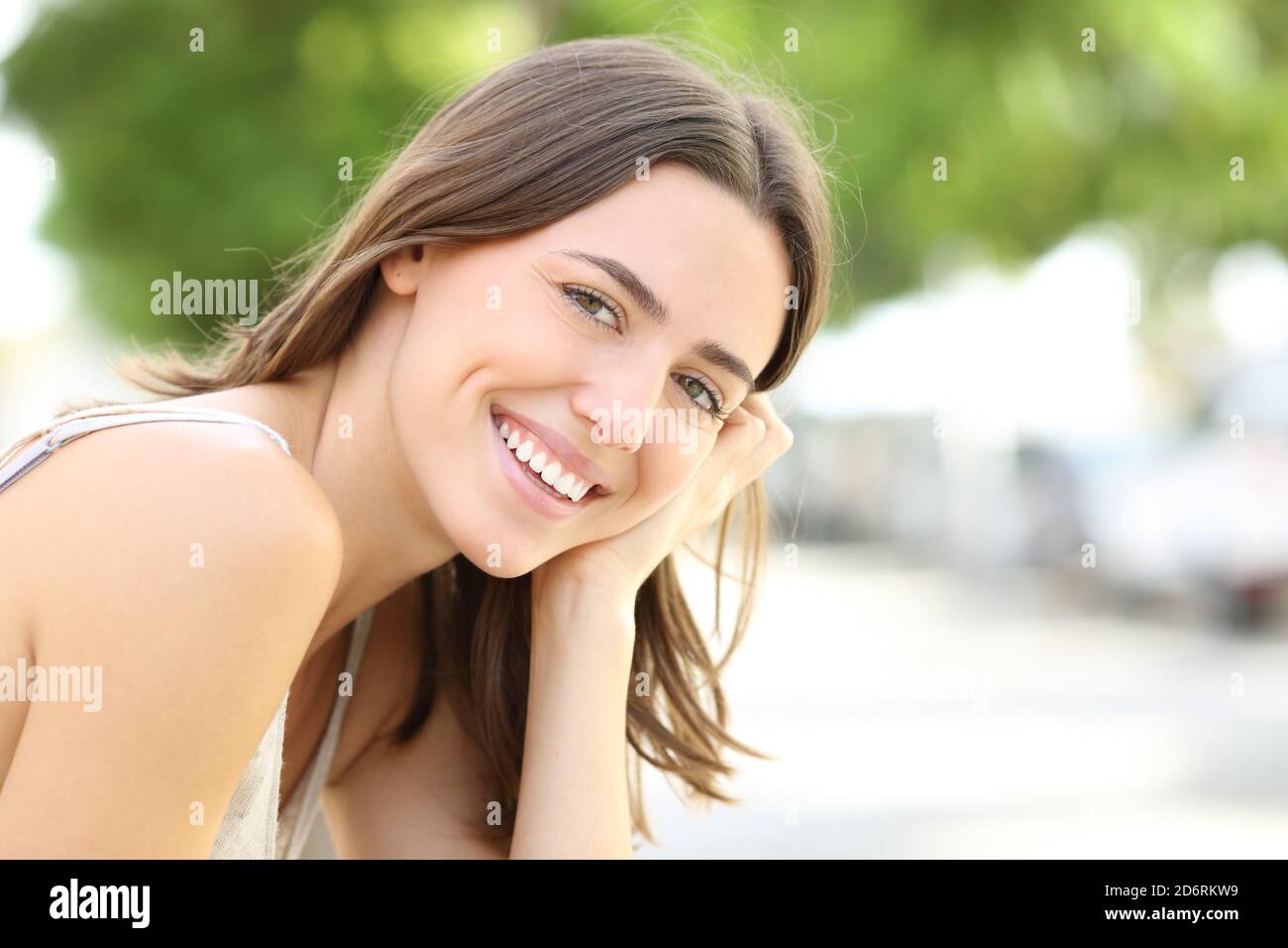 Glückliche Frau mit perfektem Lächeln schaut in die Kamera Straße Stockfoto